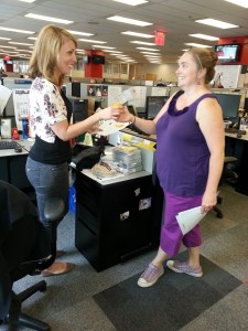  Naomi hands Jamie an orange during  the “Peel Away from Your desk Campaign"